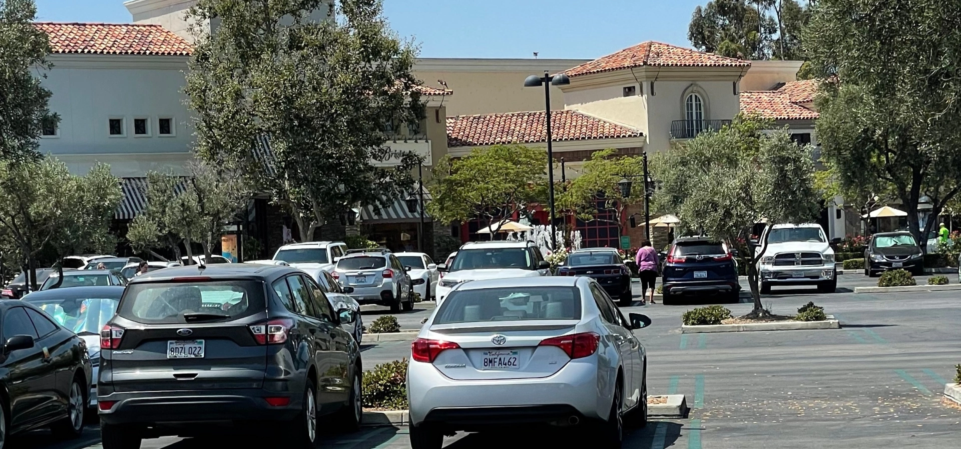 Parking lot with cars near shopping center.