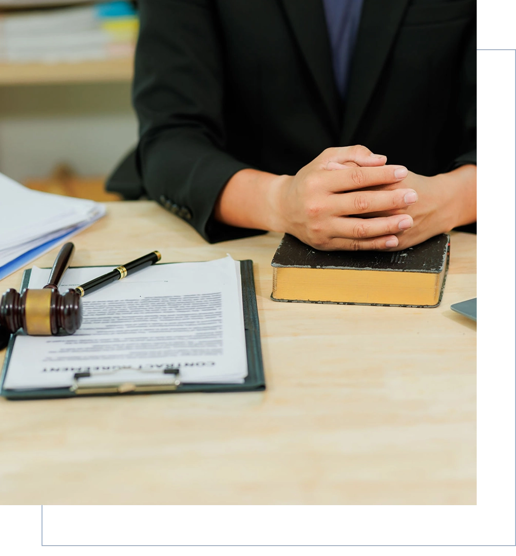 Seated person with gavel and legal documents.